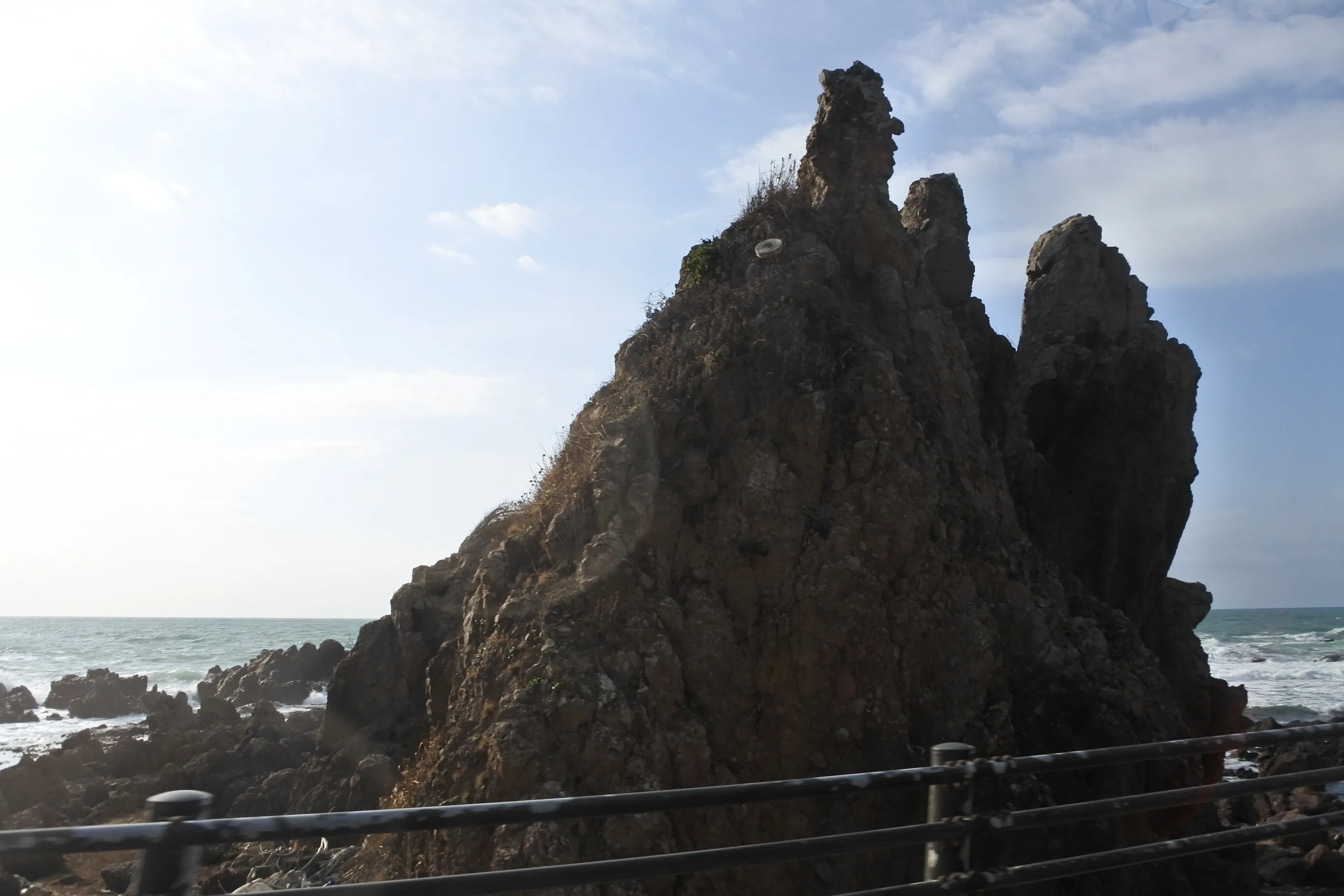 Gunkanjima, a battleship-shaped sea stack, its outline picked out by the white surf