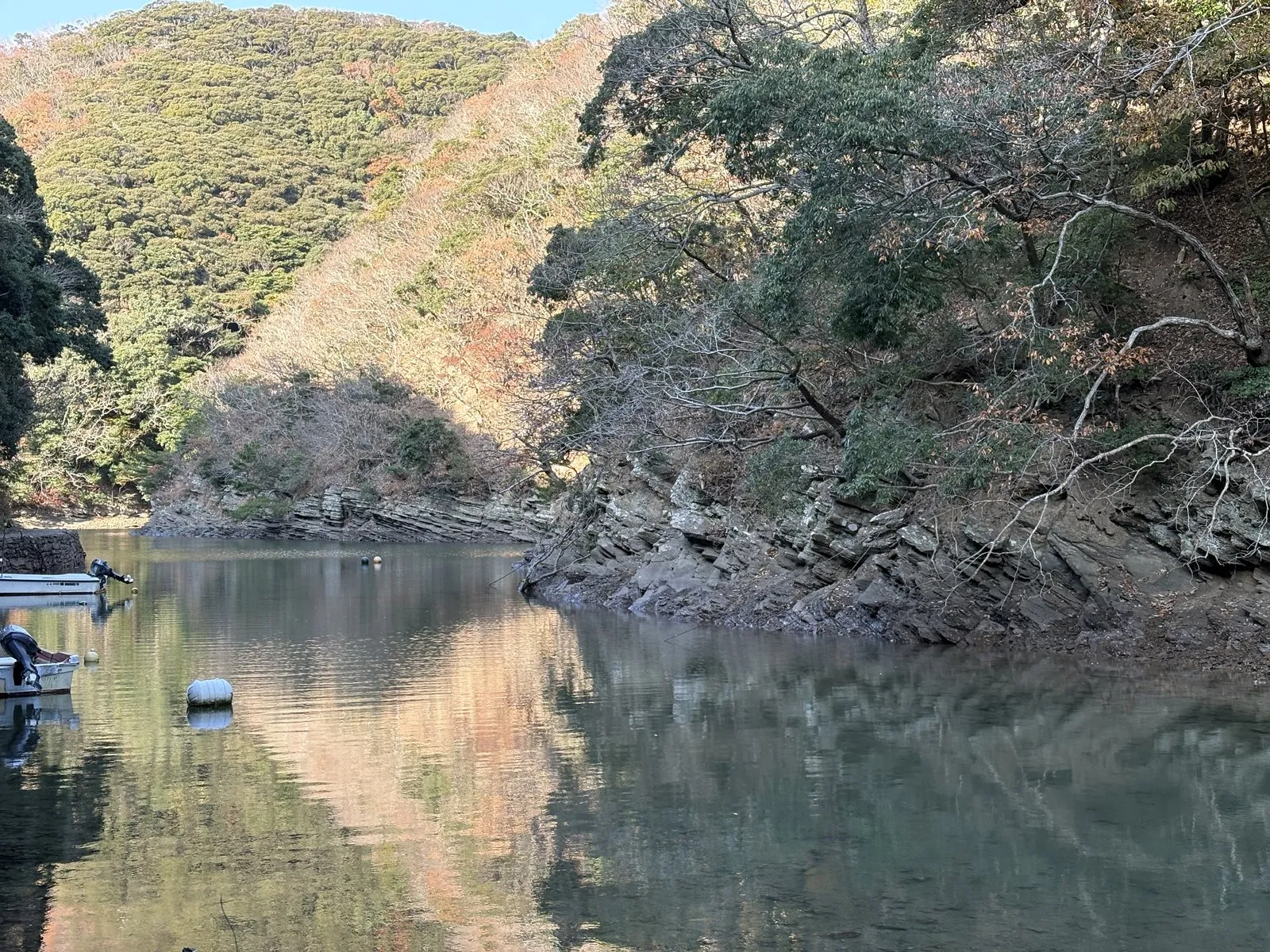 西漕手の入り江。鏡のように静かな水面に山が映り、小舟が浮かんでいる