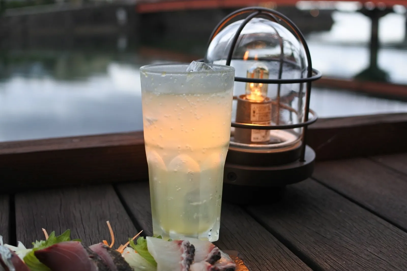 散歩亭のテラス席。刺身の盛り合わせと屋久島酵素スカッシュ、ランタンの灯り